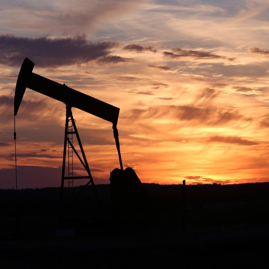 A pumpjack silhouetted against an orange and purple West Texas sunset.